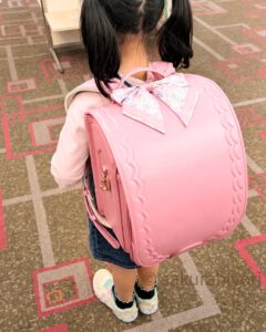 グリローズのランドセルを試着する女の子｜ピンクカラー展示会レビュ